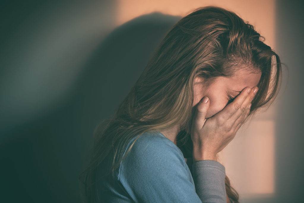 girl crying in the corner asking herself if drug addiction is a disability