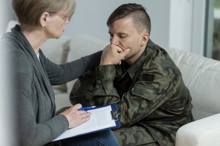 photo of mature psychologist and despair soldier with ptsd