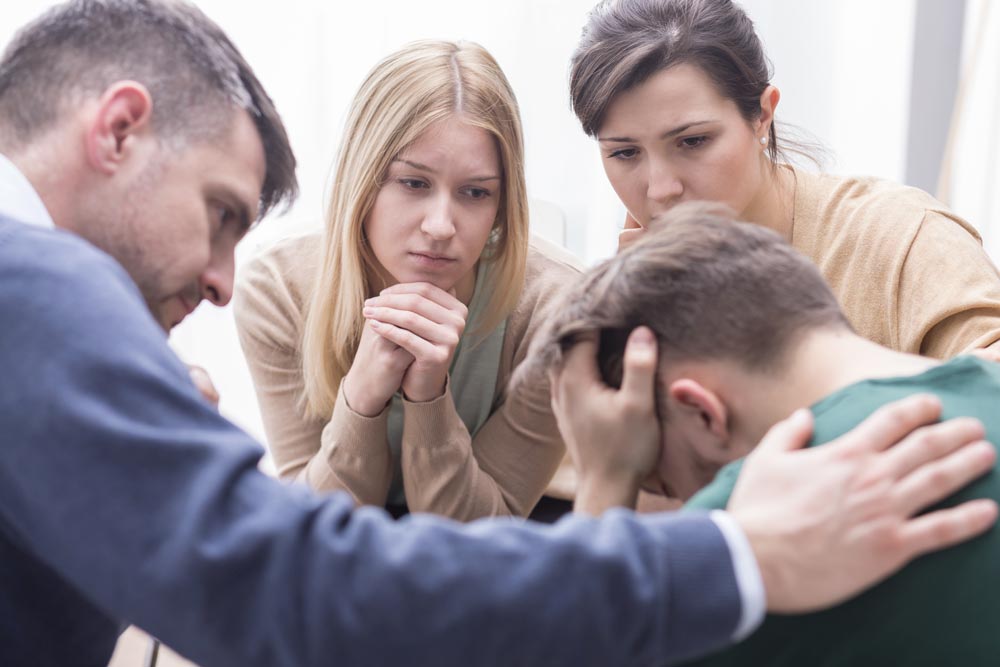 photo of people from Alcoholics Anonymous organization listening to a male patient during therapy