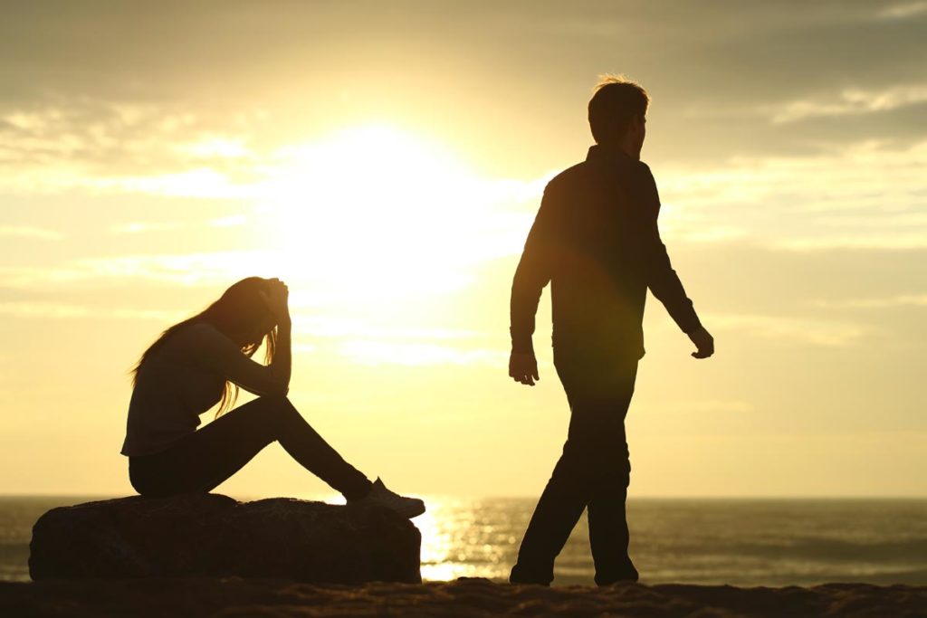 photo of a man walking away from his upset wife