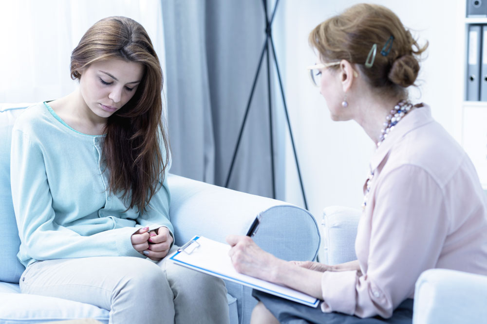photo of a female patient talking to her therapist about her treatment