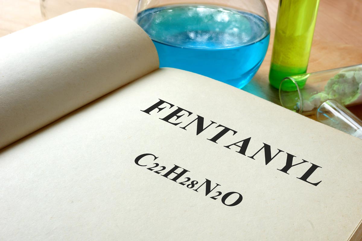 a book with fentanyl text written on it and test tubes around the book