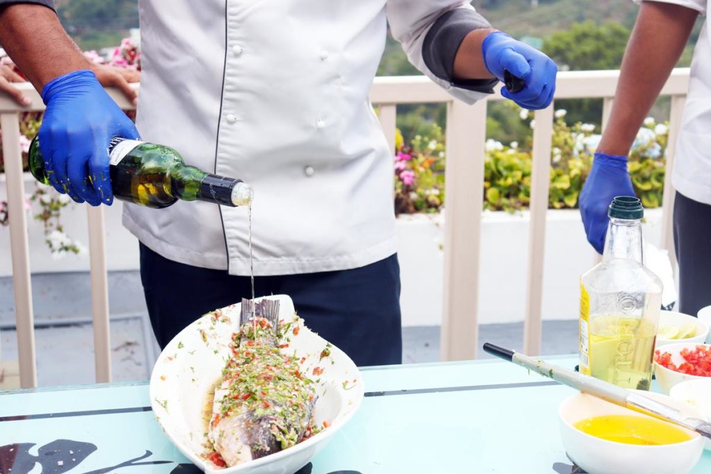 a chef is using a white wine in the food he is preparing