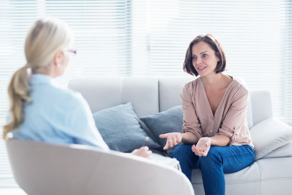 Psychologist talking about getting to rehab to a female client
