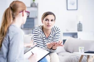 addiction rehab female staff discussing insurance options with a female client