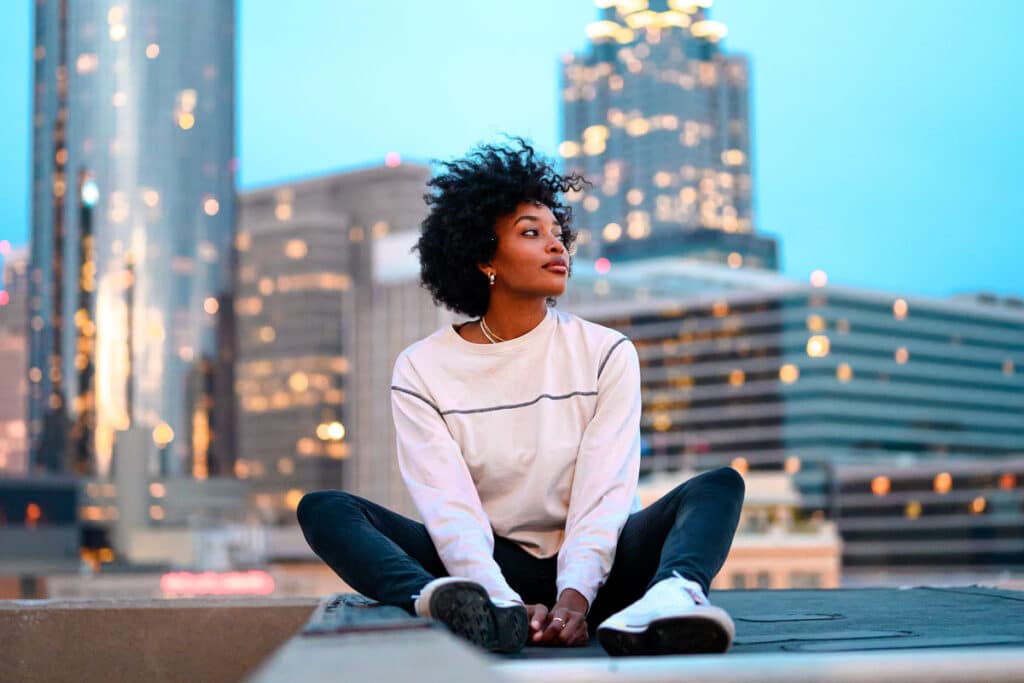 lonely young adult sitting at the building's roof top