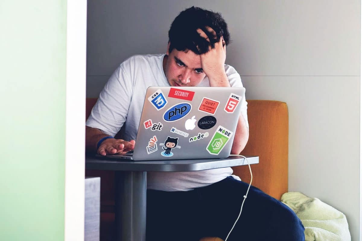 man infront of his laptop working struggling with anxiety and stress