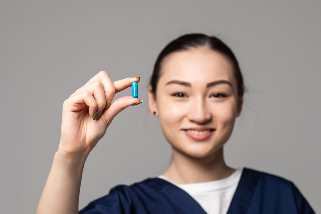 A nurse holding up a capsule of Vyvanse; give us a call if you're suffering from addiction.