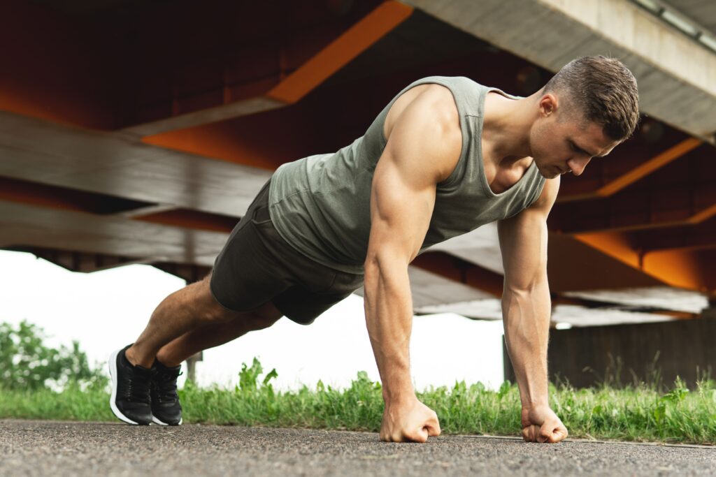 A young man doing pushups as a mechanism to stop smoking weed.