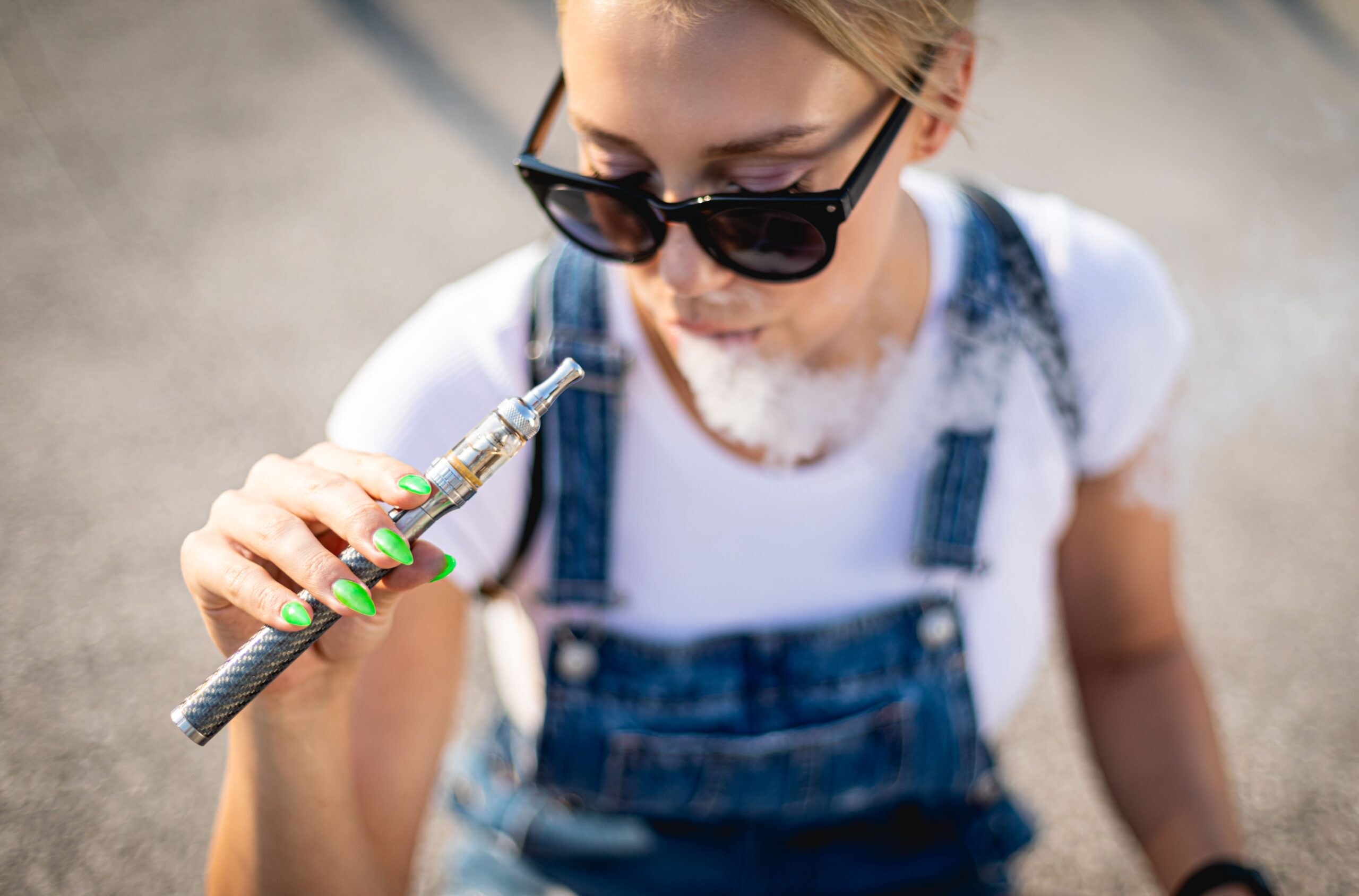 How Long Does Weed Pen Stay in Pee?-modern-woman-outdoor-smoking-e-cigarette-while-sit-2024-10-31-00-59-14-utc (1).jpg